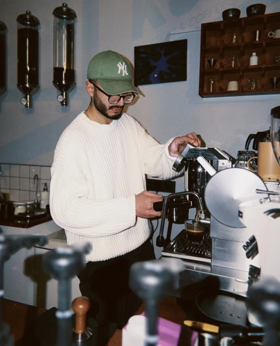 Kupi baristası espresso makinesinde kahve hazırlarken